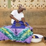 Woman enjoying ironing gara cloth in the shade