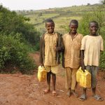 Boys carrying water containers